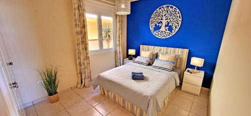 een blauwe slaapkamer met een bed en een blauwe muur bij Ferienwohnung Jandia Dream in Morro del Jable