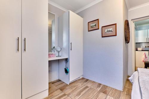 einen Flur mit weißen Schränken und einem Schreibtisch in einem Zimmer in der Unterkunft Lonehill Arnheim- Cottage 1 in Sandton