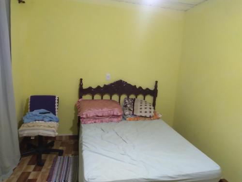Pedro de Toledo的住宿－Casa e cachoeira，卧室配有一张床铺,位于一个黄色墙壁的房间