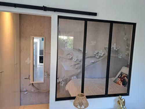 Séduisant studio avec cour privative في لا كراو: غرفة بها نافذة بها سرير ومرآة