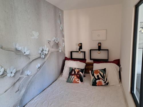 a bedroom with a bed with two pillows on it at Séduisant studio avec cour privative in La Crau