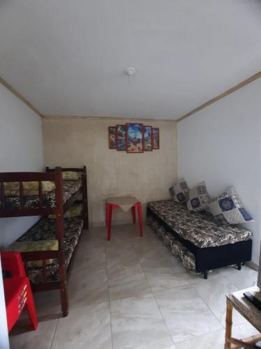 een kamer met een stapelbed en een bed en een bank bij kitnet Guilhermina PG in Praia Grande