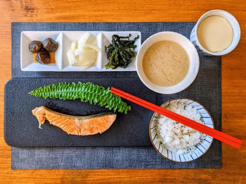 a plate of food with sushi and rice and chopsticks at 甘澄民宿 700坪綠意庭院與手作早餐 in Jian