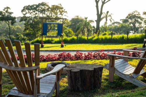 a couple of chairs and a table in a park at Chalés Quinta da Boa Vista in São Bento do Sapucaí