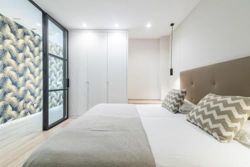 ein Schlafzimmer mit einem großen Bett und einem großen Fenster in der Unterkunft Smartr Las Palmas in Las Palmas de Gran Canaria