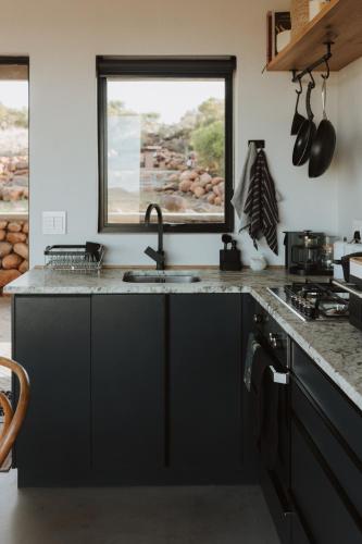 a kitchen with a sink and a window at Spionkop Eco Cabin in Reddersburg