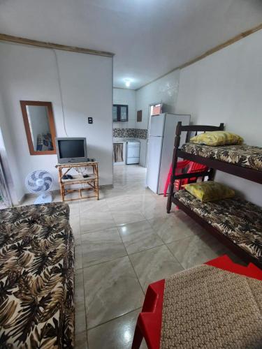 een woonkamer met een bank en een koelkast bij kitnet Guilhermina PG in Praia Grande