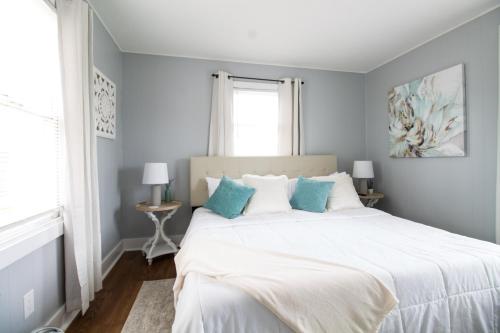 ein Schlafzimmer mit einem großen weißen Bett mit blauen Kissen in der Unterkunft The Sanctuary Company Johnson City in Bristol