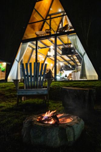 a fire pit in a yard with a chair and a tent at Chalés Quinta da Boa Vista in São Bento do Sapucaí