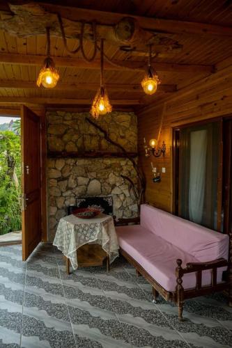 a living room with a couch and a stone fireplace at Villa Mutaf in Kumluca