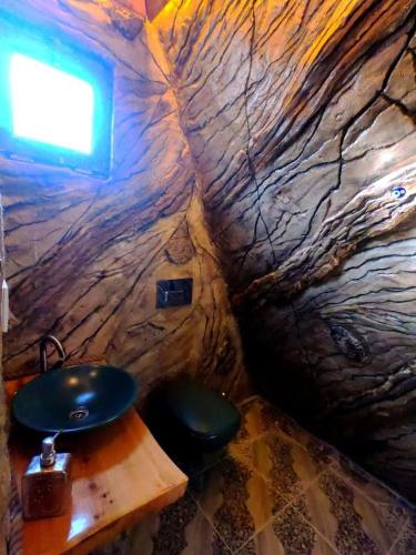 a bathroom with a stone wall with a sink at Villa Mutaf in Kumluca