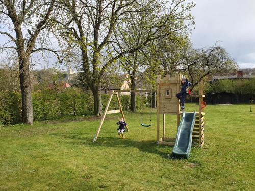 un niño jugando en un columpio en un parque en Landhaus Saaleck en Naumburg