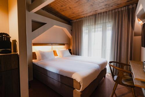 a hotel room with a bed and a window at Hotel van de Vijsel in Amsterdam