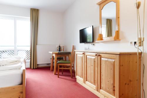 a bedroom with a bed and a table and a mirror at Mahorko Wein Wellness Wasserbüffel in Glanz an der Weinstraße