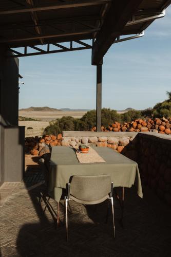 a table and chairs sitting under a roof with pumpkins at Spionkop Eco Cabin in Reddersburg