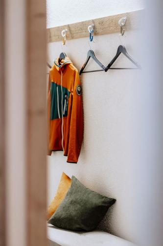 two jackets hanging on a wall with a pillow at Das Schutzhaus-Bed and Breakfast-Dein Basislager im Salzkammergut in Bad Aussee