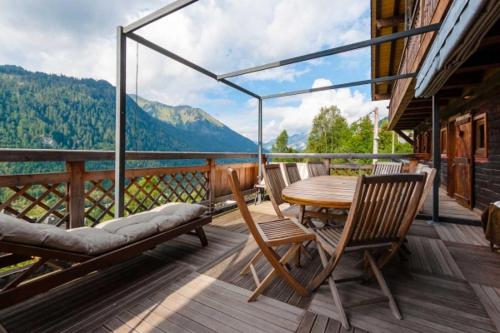 a wooden deck with a table and chairs on a balcony at Chalet La Voraz in Châtel