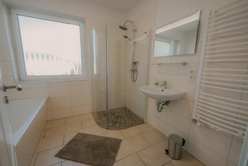 a white bathroom with a shower and a sink at Gästehaus zum Schloßpark in Schwerin