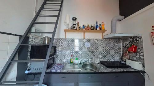 una pequeña cocina con una escalera sobre un fregadero en Funchal 19, en Funchal