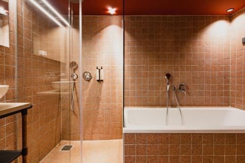 a bathroom with a shower and a bath tub at Hotel van de Vijsel in Amsterdam