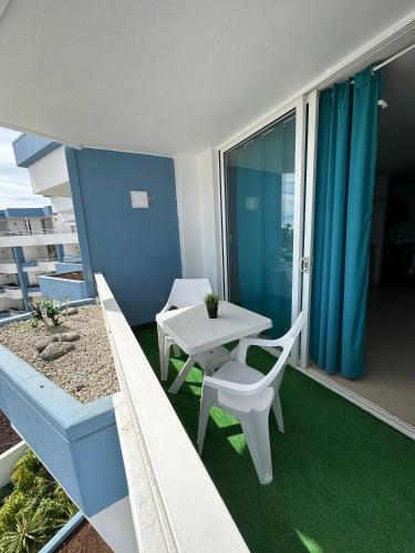 a balcony with a table and a table and chairs at Golf del Sur Tenerife - Casa Barrera verde green park la corbeta in San Miguel de Abona