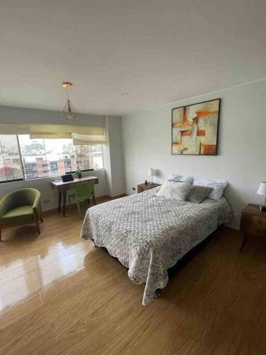 a bedroom with a bed and a table and a desk at Excelente ubicación San Isidro Suite 11 in Lima