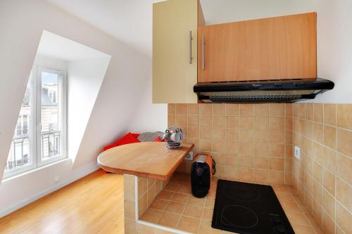 une petite cuisine avec une table et un évier dans l'établissement CHAMPS DE MARS - LAOS, à Paris