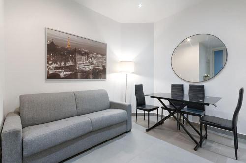salon z kanapą, stołem i lustrem w obiekcie Batignolles Lemercier Cosy Apartment 4P-1BR w Paryżu