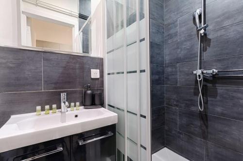 W łazience znajduje się umywalka i prysznic. w obiekcie Batignolles Lemercier Cosy Apartment 4P-1BR w Paryżu