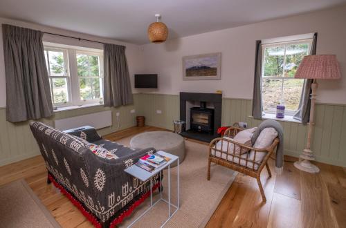 a living room with a couch and a table at Isle of Skye luxury cottage near Portree in Kensaleyre