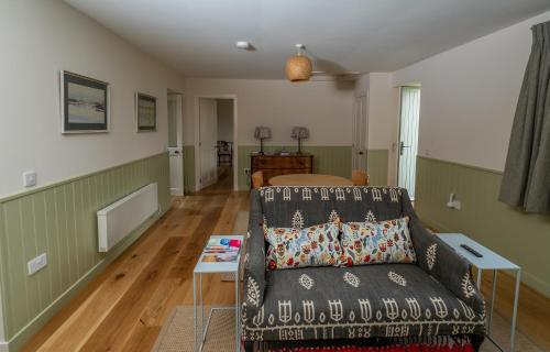 uma sala de estar com um sofá e uma cama em Isle of Skye luxury cottage near Portree em Kensaleyre