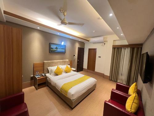 una camera d'albergo con letto e sedia di Taj Metro a Maulvi Bāzār