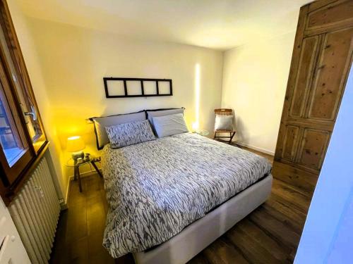 1 dormitorio con 1 cama y suelo de madera en Le Bon Bon CIR-TORGNON-0017 en Torgnon