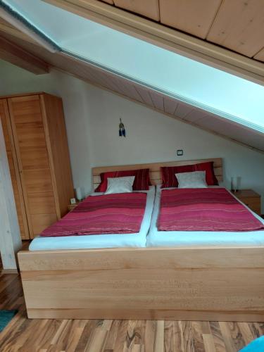 エーギングにあるHaus Kerstanのベッドルーム1室(赤いシーツを使用した大型ベッド1台付)