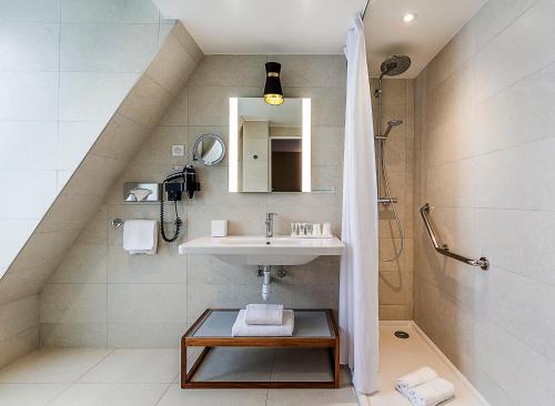 uma casa de banho com um lavatório e um chuveiro em Hotel La Manufacture em Paris