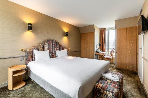 Hotel La Manufacture في باريس: غرفة فندقية بسرير كبير وكرسي