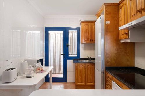 una cucina con armadi in legno e una porta blu di Casa Famara a Famara