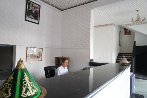 a woman sitting in a chair in a room at Hotel Warda in Ouarzazate