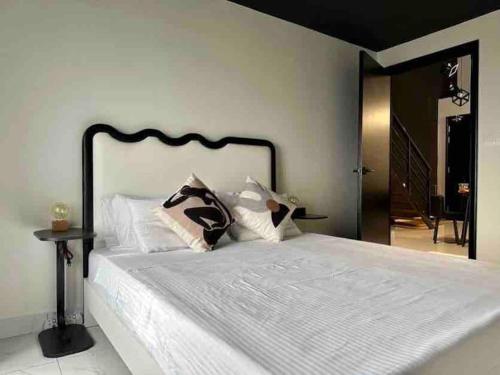 una camera da letto con un grande letto bianco con testiera nera di NEW Insta Worthy B&W Designer Loft in Cheras, KL 