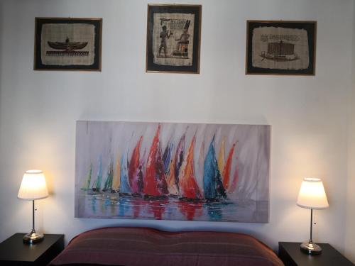 a painting on the wall of a bedroom with two lamps at A due passi dal mare in Varazze