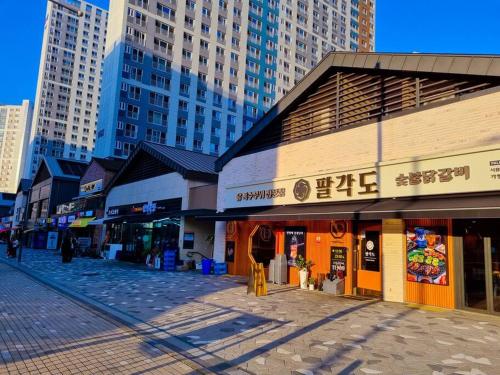 una calle vacía en una ciudad con edificios altos en Stay Colorido, en Siheung