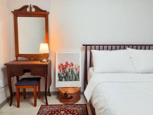 始興市的住宿－Stay Colorido，一间卧室配有一张床和一张带镜子的桌子
