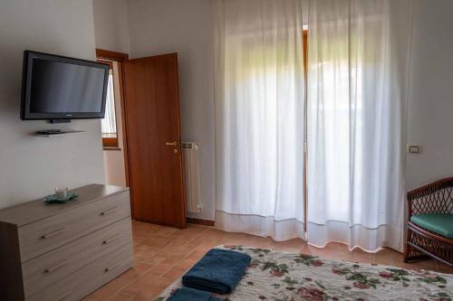 een woonkamer met een televisie op een dressoir en een raam bij Residenza Lucia in Campagnano di Roma