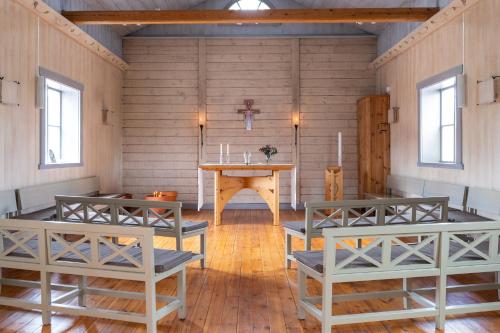 a room with a table and benches in it at STF Undersvik Gårdshotell & Vandrarhem in Vallsta