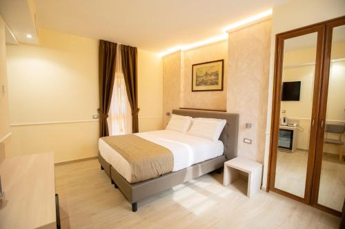 a bedroom with a bed and a mirror at Hotel Maximus in Rome