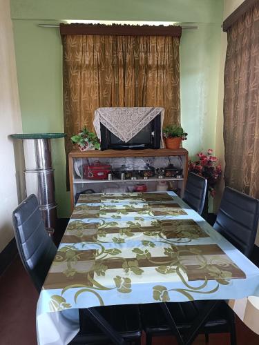 einen Tisch mit Stühlen und einen Tisch mit einer Tischdecke darauf in der Unterkunft Banraplang syngkrem house in Shillong