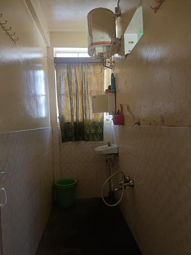 ein Bad mit einem WC, einem Waschbecken und einem Fenster in der Unterkunft Banraplang syngkrem house in Shillong