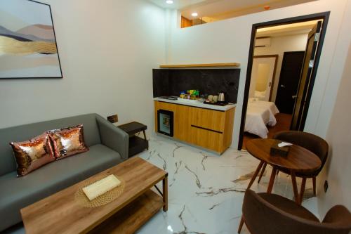 a living room with a couch and a tv and a table at Rockfort Hotel in Cotabato