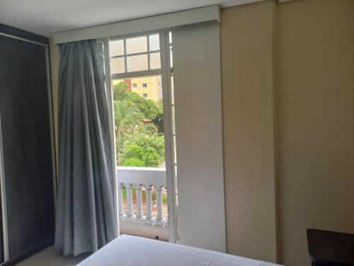 a bedroom with a window with a view of a balcony at Flat - Apartium Palacete Victória in Sao Paulo