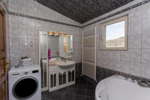 a bathroom with a sink and a toilet and a tub at Villa Almas - Heated Pool, Sauna, Gym and Tennis Court in Neorić
